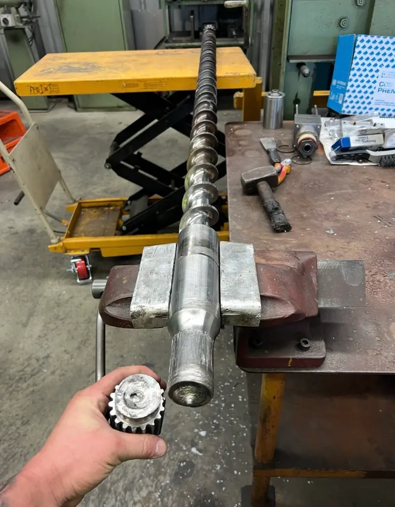 Machined shaft and gear in workshop vice