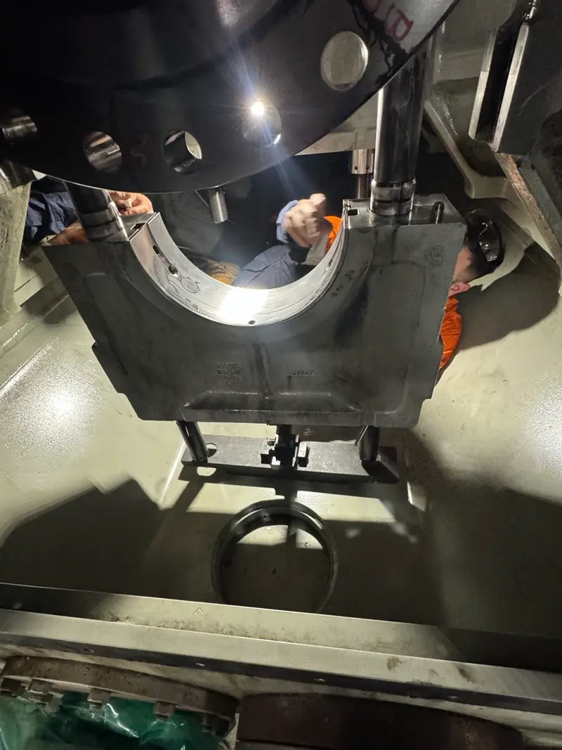 Technician inspecting heavy machinery internals on-site